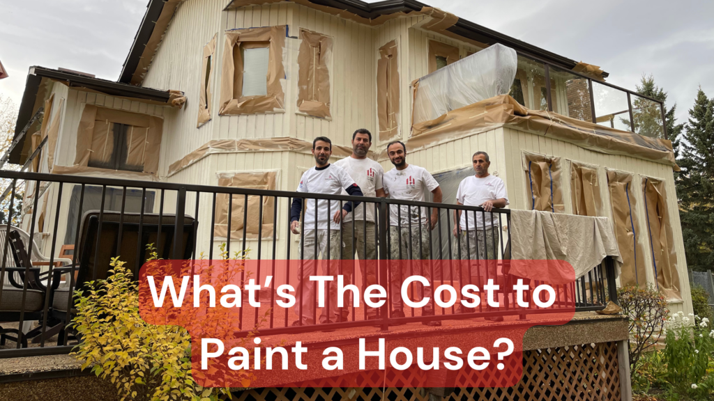 A team of painters in front of a house they are painting