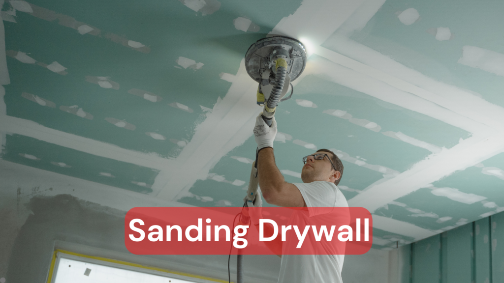 A tradesmen sanding drywall with a professional grade sanding tool