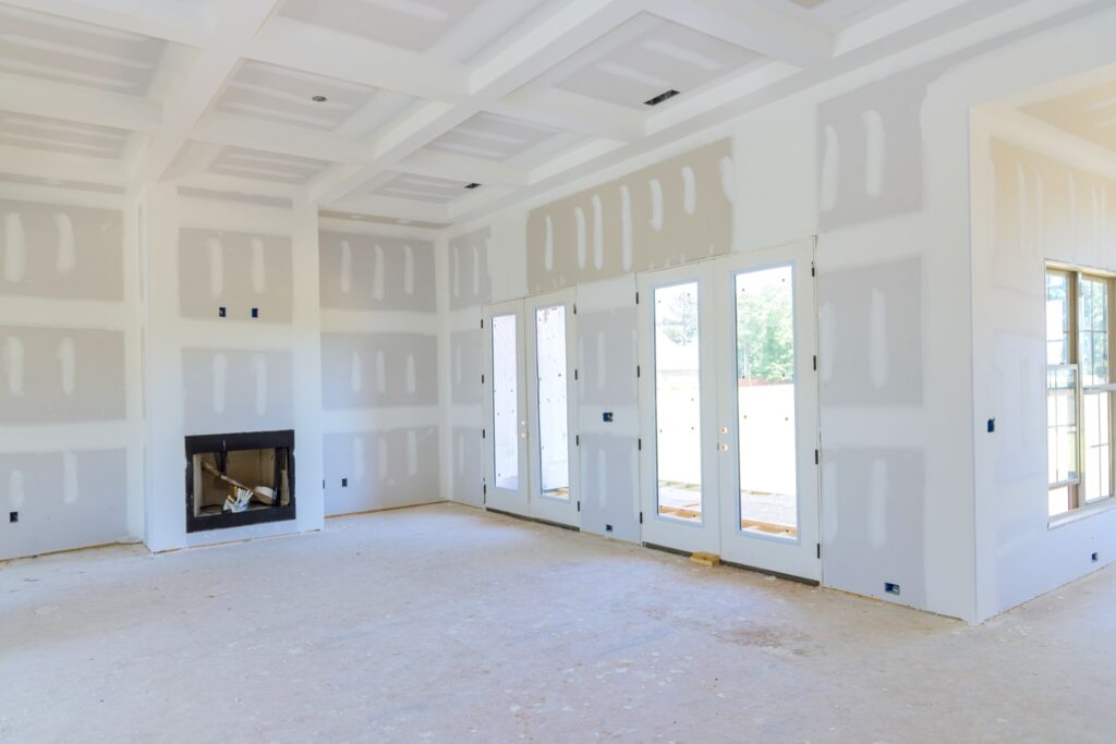 Plastering drywall in preparation for painting in newly constructed house