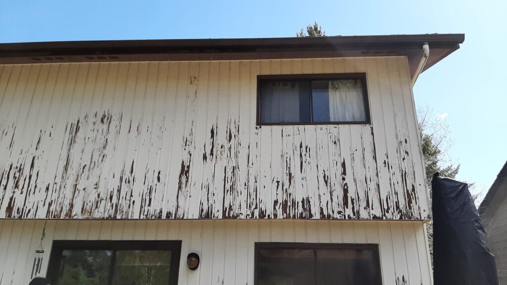 worn out and falking paint on the exterior oa a cedar siding home