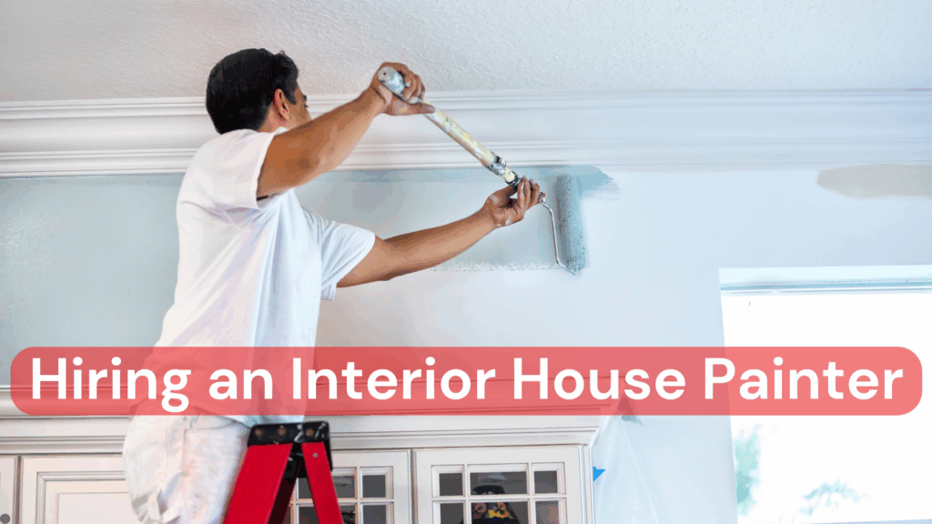 An interior house painter up on a ladder painting a wall in a house